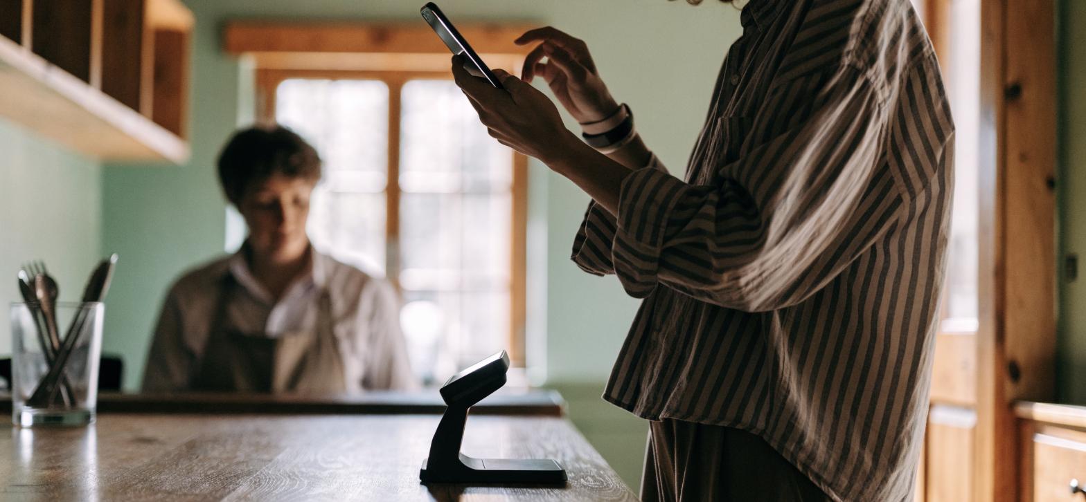 Guest scanning a McAlister's Rewards QR code from a phone at the restaurant counter to earn points